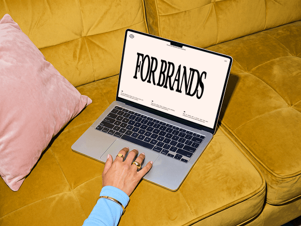 macbook mockup on a sofa with a hand