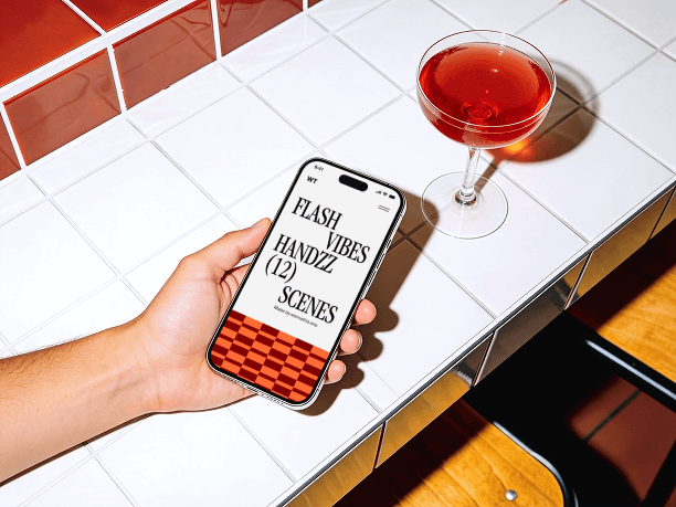 hand holding iphone on tiled table scene